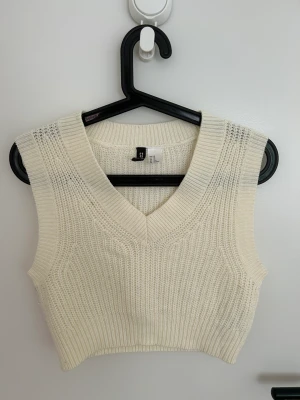 Stickad väst  - Kroppad stickad väst perfekt att ha över en skjorta. Knappt använt skick 