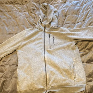 Sail raicing hoodie - Säljer min sail raicing tröja för har tröttnat. Den har några fett fläckar på ena armen. Den har 2 små hål i sig