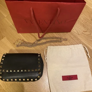 Valentino garavani väska (Rockstud leather crossbody bag) - Köpte på Vestiaire collective för ca ett halvår sedan (såklart äkta) och har knappt andvänt den sen dess. Förra ägaren tappade bort bandet till väskan så de bandet på bilden är inte valentino men medföljer om så önskas! Skriv för fler bilder eller frågor!
