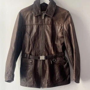 Brun läderjacka med bälte - Brun läderjacka köpt second hand -Aldrig använd, prislappen kvar Strl - 36/38