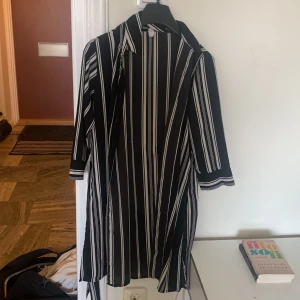 Skjortklänning / kofta  - Jättefin svartvit randig klänning som man knyter runt sig men som även kan användas som kofta. Inga tecken på användning.