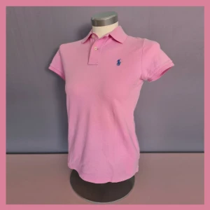 Rosa Ralph Lauren polo  - Rosa Ralph Lauren polo tröja med blått märke. Den är i storlek S men det är i en skinny/smalare modell. Sparsamt använd och i gott skick! 🎀