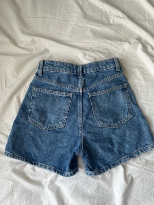 Högmidjade shorts från Zara - Högmidjade blå shorts från Zara! Shortsen är superbekväma och har den perfekta längden. Pris kan diskuteras!  Mått: midja: 34cm (mätt platt) höft: 47cm (mätt platt) längd: 36cm 