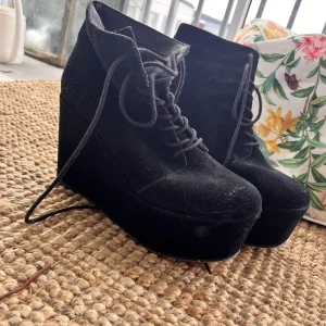 Platåsko - Svarta platåskor. Köpta second hand o säljer för de aldrig används. Lagt bort skorna nu men kollar märket vid intresse. Något okänt märke är det iallafall.