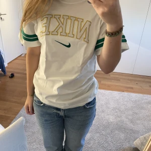 Oversized Nike t-shirt  - Vit t-shirt med gröna detaljer och Nike logga, vintage format. Mycket bra skick och stor i storleken (var väldigt lång, men snygg) storlek XS