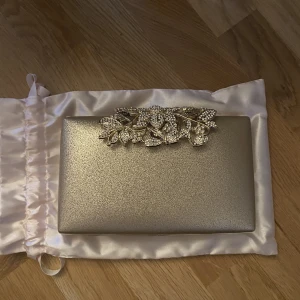 Väska - Kuvertväska i glittrande guld, super fin aldrig använd perfekt inför val bröllop,fest m.m 💕