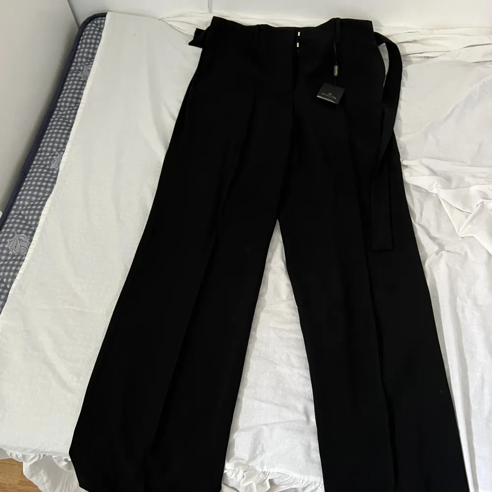 Oanvända svarta kostymbyxor med prislapp kvar. Jeans & Byxor.