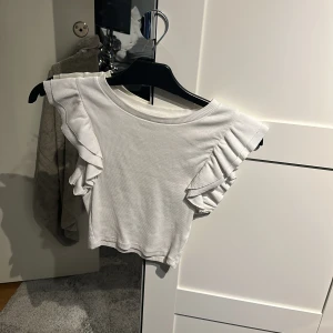 Vit topp - Vit topp med volang i armarna ifrån zara, säljer en exakt likadan fast svart 