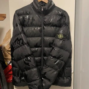 Vinterjacka - Vinterjacka FAKE Stone island Vet inte storlek men skulle tippa på L, högts upp det det ut som att något,  har fastnat på camoflagen, går eventuellt att tvätta bort eller täcka över! Använd men i gott skick 