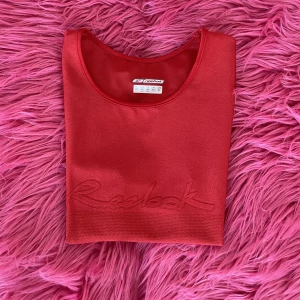 Sportig Reebok topp - Röd ärmlös Reeboktröja i sportigt material. Använd ett fåtal gånger!