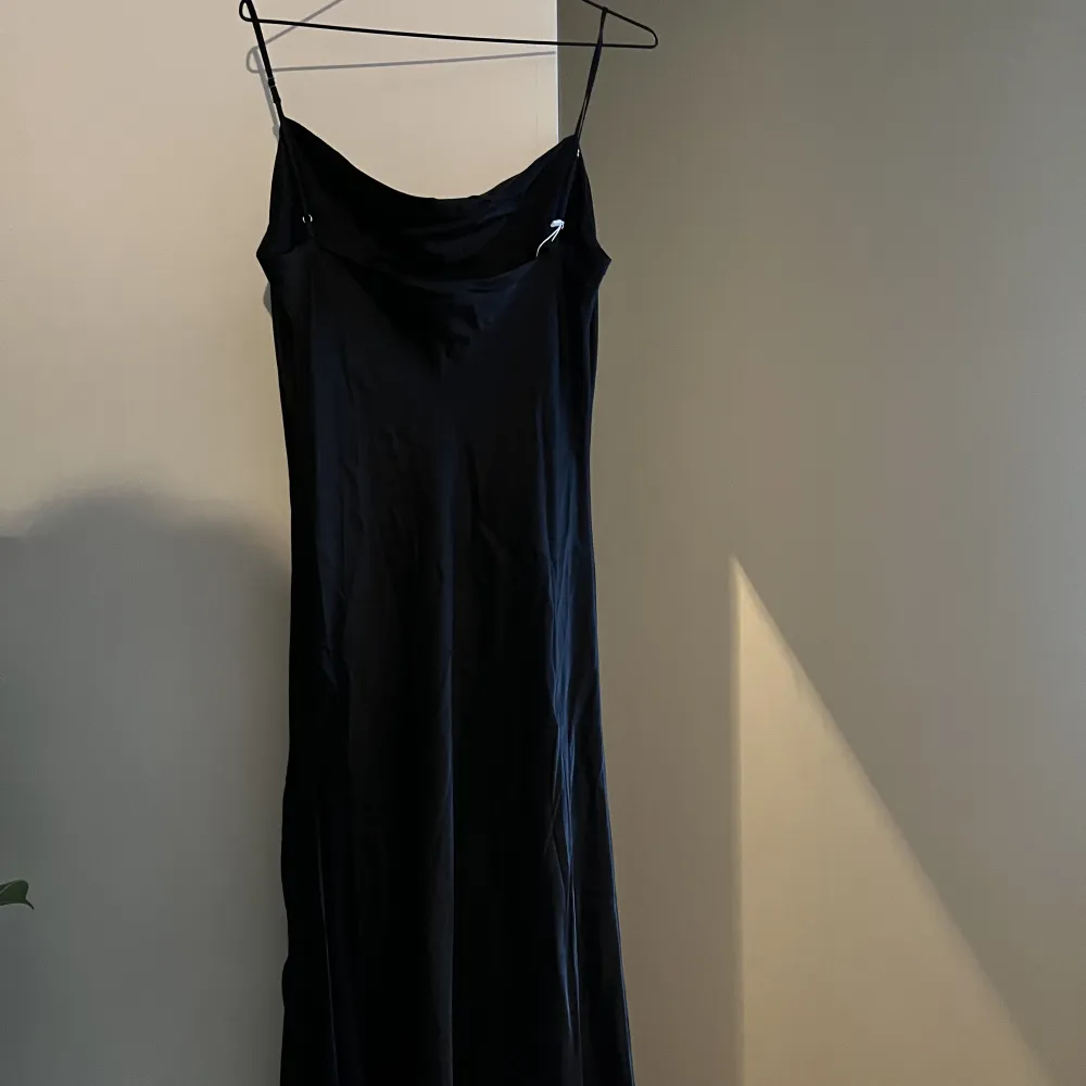 Svart ”siden” långklänning med drapering (tror jag de heter) upptill och slits längst ner. Perfekt till sittning eller bal!. Klänningar.
