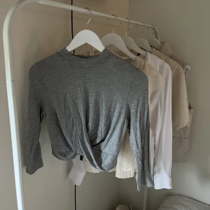 Grå topp med korsning - jättefin grå topp med en korsning framtill i strl XS/S🤍