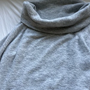 Off shoulder tröja från H&M - Grå stickad off shoulder tröja från H&M! Säljer den eftersom den är för stor och inte kommer till användning! Perfekt nu till hösten!! Skulle säga att den passar S och M