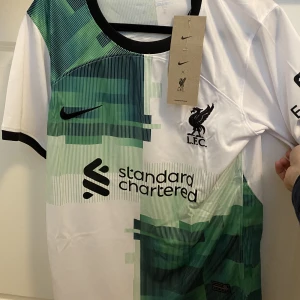 Oanvänd Liverpool borta kit 22/23 tröja - Snygg och Helt oanvänd Liverpool tröja i felfritt skick. Köpt i England för cirka 900 kr. OBS färgen ser bättre ut i verkligheten