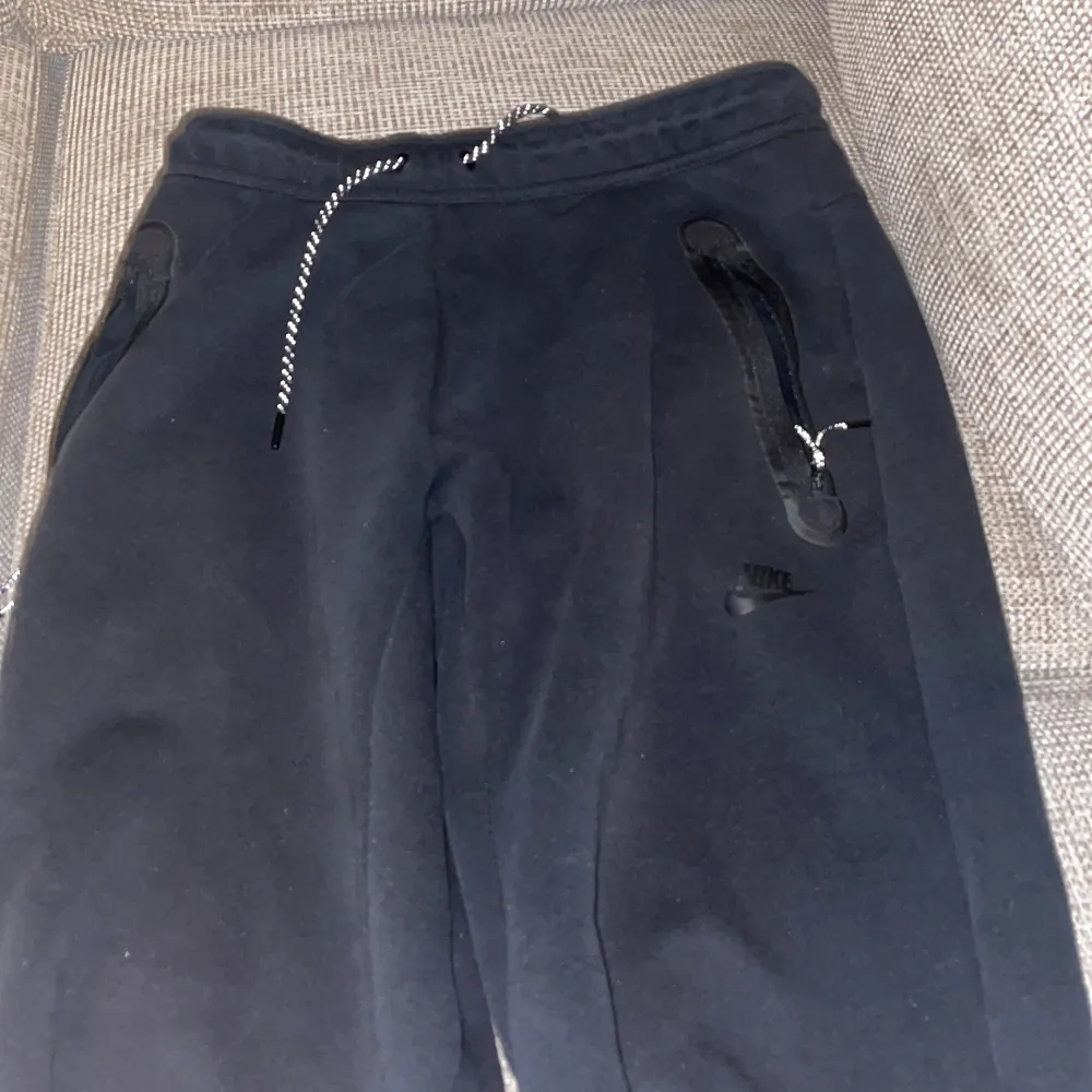 Svarta Nike tech byxor Size M direkt från butik . Jeans & Byxor.