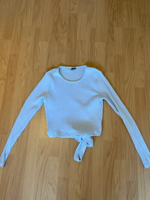 Topp från ginatricot - Ljusblå topp från ginatricot med knyte i ryggen, storlek M!