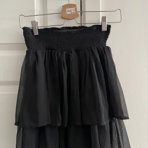 Volang kjol/topp  - En svart volang kjol som kan användas som topp med om man vill. 