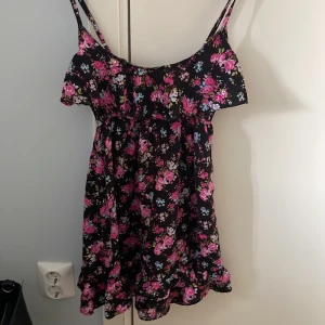 Blommig klänning  - Blommig klänning med justerbara band, vet inte vart den är ifrån eller storleken men den passar på mig som har xs (ganska kort) 