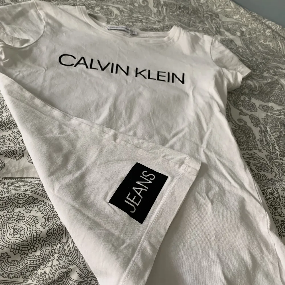 Jag säljer nu min vita Calvin Klein t-shirt då den är för liten. Den är inte använd så många gånger så den är i bra skick. Storleken är 12y vilket motsvarar xxs/xs. . T-shirts.