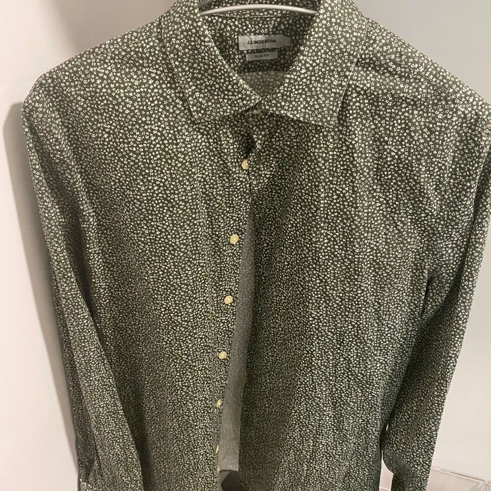 Sommrig skjorta med blommig motiv, grön med vite detaljer använd till en tillställning (nyskick). Skjortor.