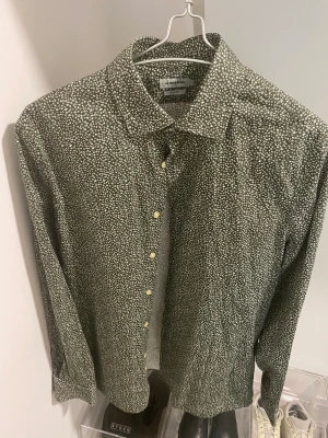 J.Lindeberg Skjorta - Sommrig skjorta med blommig motiv, grön med vite detaljer använd till en tillställning (nyskick)