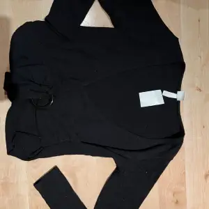 En oanvänd svart omlott tröja från hm. Finf och skönt material 