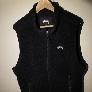 Stussy Väst i Teddy - Hej, säljer en riktigt grym väst från Stüssy i bra skick. Den är i storlek M men passar även L. 100% polyester och väldigt bekväm att ha på sig. Passar till allt och perfekt inför sommaren. Priset är inte hugget i sten. Hör av dig!