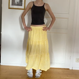 Gul maxikjol - Gul långkjol med vita små blommor från H&M. Blir maxikjol på en kortare men mer åt midihållet om man är lite längre. Strl 36 men ganska kort, min syster på bilden är 168 cm och har den ganska lågmidjat 💛🤍 Använd gärna köp nu! 