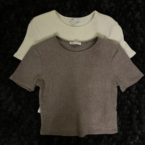 Zara toppar - Säljer 2st Zara- toppar i fint skick. (Vit och brun) Lite ribbstickad känsla i mönstret  och dom har  små tunna  axel-vaddar. Dom är korta i modellen och passar fint till jeans. Säljer för 50kr/st eller båda för 80kr.  Kan mötas upp å slippa frakt!!