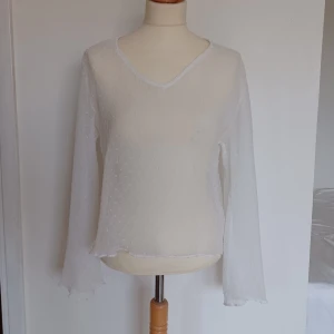 Mesh topp - Genomskinlig långärmad mesh topp med små vita prickar och utsvängda ärmar. Superfin som den är eller under en t-shirt. Fint skick