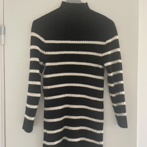 Stickad klänning - Svart och vit randig stickad klänning. Köpt på HM, aldrig använd.