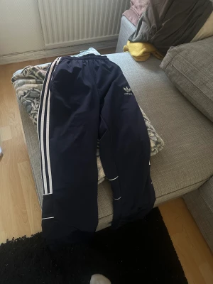 Adidasbyxor retro  -  Adidasbyxor retro vintage.  Mycket bra skick . Skulle säga att storlek är S-L . Vida ben ,Fickor med dragkedja och snöre på på insidan av byxorna . Har ni frågor så det bara skriva . Köparen står frakten