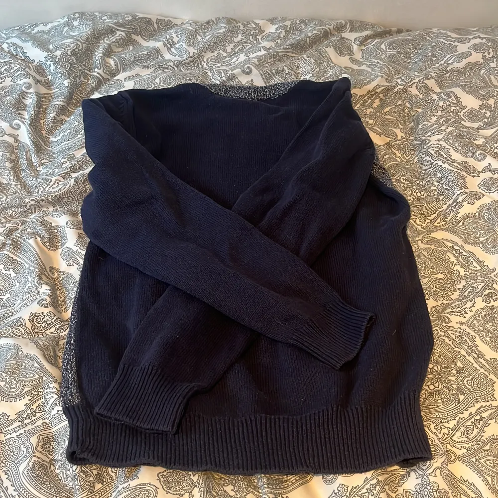 En tröja som är i 9/10 skick och har inga defekter den är i storlek 146-152 cm och är mörkblå på ärmarna och grå i mitten. Stickat.