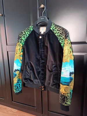 Versace x H&M - Sällsynt jacka som är svårt att få tag på. Köpte jackan och trodde att M skulle passa men då jag gått till gymmet så har jag bytt storlek till L och letar nu samma jacka i storleken L. Hängaren i nacken är påväg att lossna, 100kr hos skräddare för att fixa.