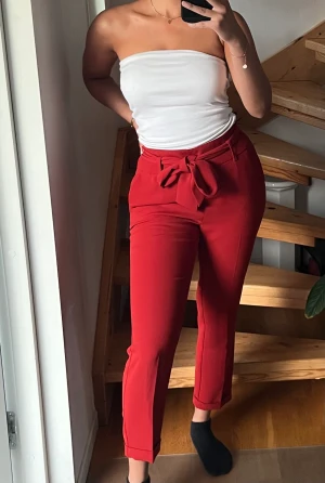 Byxor  - ”kostymbyxor” med en rosett i fram. Bra kvalitet och superfin röd färg!  Är i fint skick men har en liten anmärkning vilket kan ses på sista bilden (är på låret)🫶🏻