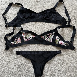 Två bikinis  - Bikini från H&M. Två överdelar i storlek 40, en svart och en blommig, samt trosor i storlek 34. 