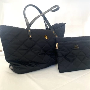Ralph Lauren väska  - Ralph Lauren väska med tillhörande mindre kuvertväska/nessesär som går att fästa på insidan av stora väskan med hjälp av knappar.  Väskorna är i fint skick.  Väskan är köpt på Zalando.  Nypris, 2000kr  Stora väskan ca, 40x27cm  Kuvertväska ca, 22x20cm.