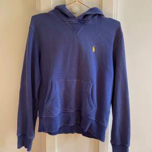En blå hoodie från Ralph Lauren som har visa defekter på ärmarna men annars i hyfsat fint skick