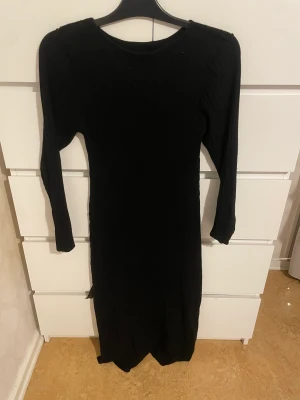 Klänning  - En svart klänning som är ribbad den sitter inte tajt och är skön.