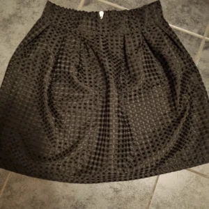 Kjol med klockmodell och mönster  - Lite glansig i tyget och sitter åt i midjan rätt bra och faller ner och ut precis som på bilden 😄 Mönster som prickar över kjolen. Stängs med dragkedja baktill. 