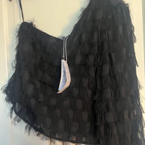 One shoulder top - En jättefin svart fluffy one shoulder top. Aldrig använts, så helt ny med prislapp kvar. Nypris: 399kr.🖤