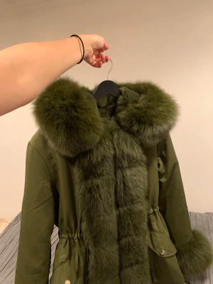 Grön pälsvinterjacka - Mörk grön, äkta och väldigt tjock päls. Inte denna typiska modell med tunn päls. Köpt i Belgrad för 2 år sedan. Använt den några fåtal utgångar.🥰 Inte använt i vardagen alls. Det går att ta av päls delarna på jackan