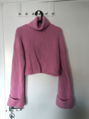 Stickad tröja croppad  - En croppad stickad tröja med polokrage från Nelly, aldrig använd Köparen står för frakten