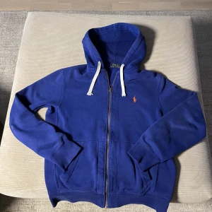 Polo Ralph Lauren zip - Hej! Jag säljer denna riktigt snygga Ralph lauren tröja p.g.a för lite användning. Skicket är 9/10 då den inte har använts så mycket. Nypris är 1800kr.