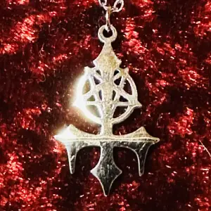 Nytt och oanvänt halsband. En magisk gåva. Silverfärgat inverterat pentagram / inverterat kors i rostfritt stål. Även kallat ”Satans fork”. Så häftigt och ovanligt. Amuletten är 3,6 cm lång och 1,6 cm bred. Kedjan 44 lång. Låses med hummerlås.