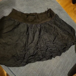 Kort kjol  - Svart, kort kjol, ca 32 cm lång. Storleken är 42/44, men jag tycker den verkar större. Midjemått ca 90cm. Välanvänd men bra skick.