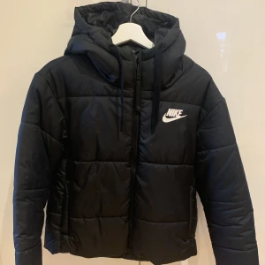 Vinterjacka Nike - Vinterjacka från Nike, strl M. Gjord för att kunna vända ut och in för att få Nike märke på ryggen om man vill ha det. Använd fåtal gånger. Kan mötas i Sthlm eller skicka som paket 