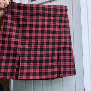 Rutig kjol - Rutig kjol med två slittar framtill och dragkedja baktill. Ganska stretchig, men utan att bli pösig. Köpt på plick men endast testad och tvättad. Kommer helt enkelt inte till användning hos mig! 🖤