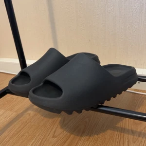 Yeezy slide onyx  - Mina nya Yeezy slides som ej passar mig längre. Skick 10/10. Lådan finns och kvitto för äkthesbevis