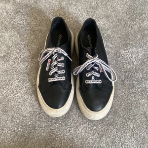 Sneakers - Svarta platå sneakers feån superga. Sulan är ungefär 5 cm som längst. Inte använda säskilt mycket o är k fint skick. Ska rengöras innan dem säljs. Köpta i London och är i äkta skinn